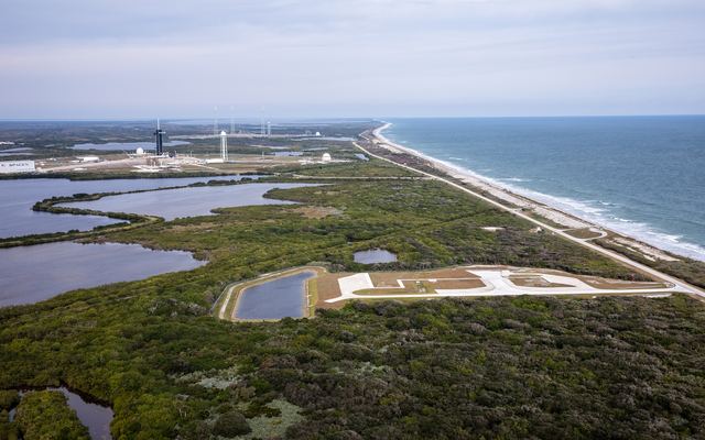 Aerial view of launch complexes along the Atlantic shoreline at Kennedy Space Center