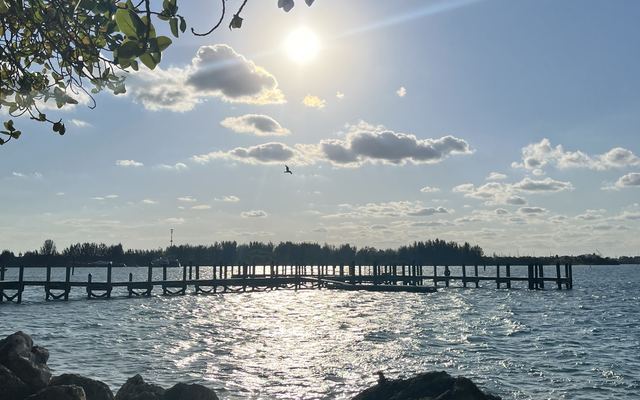A wooden fishing pier stretching across the water at Museum Pointe Park on Hutchinson Island in Fort Pierce